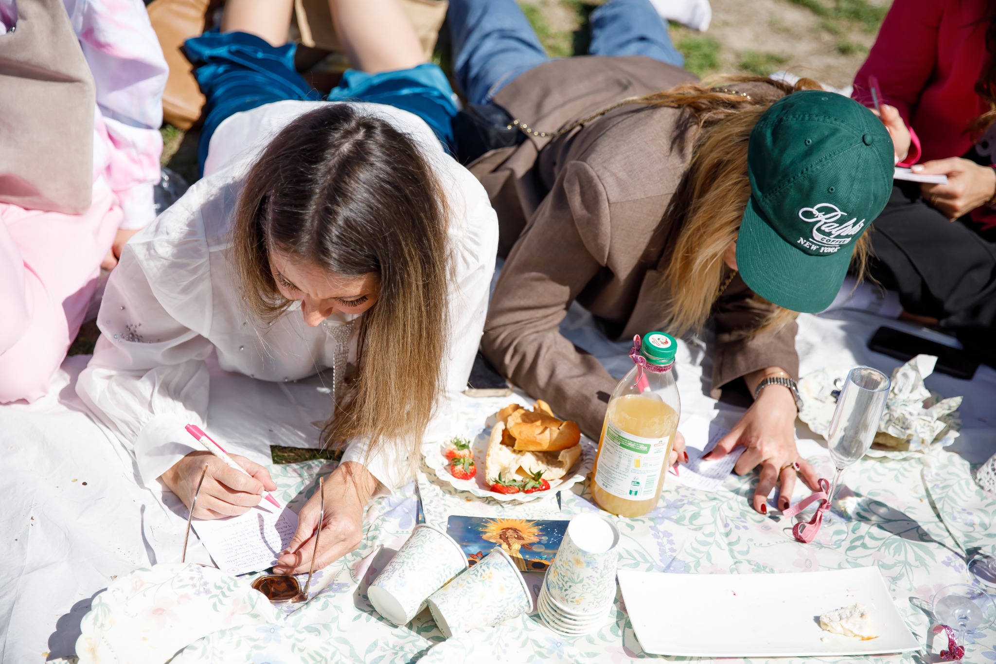 Tanya writing a letter by hand during a picnic in Paris